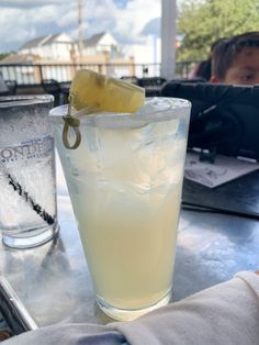 there is a drink on the table with a lemon wedge in it