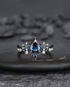 an engagement ring with a blue topazte surrounded by white diamonds on a rock