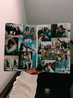 a person holding up a book with pictures on it