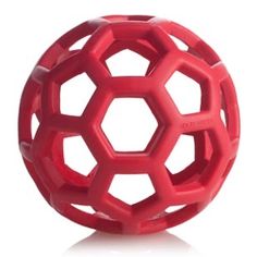 an orange rubber ball with hexagonal holes on the top and bottom, in front of a white background