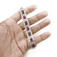 A stylish retro inspired ruby and diamond platinum bracelet. Set with Burmese cushion cut rubies 14.11 ct total. Accented by marquise and round cut white natural diamonds 6.83 ct total in floral border motifs. Diamonds are all natural in G-H Color Clarity VS. A gorgeous vintage Art Deco inspired bracelet. Length: 17.4 cm Width. 1.3 cm Weight: 46 g [shortcode] [video] [/video] [/shortcode] Luxury Red Diamond Bracelet, Red Luxury Diamond Bracelet, Luxury Red Diamond Tennis Bracelet, Luxury Red Bracelets With Diamond Accents, Red Diamond Wedding Bracelet, Red Diamond Bracelet For Wedding, Red Diamond Tennis Bracelet For Weddings, White Gold Diamond Bracelet With Ruby, Ruby Tennis Bracelet For Wedding Fine Jewelry