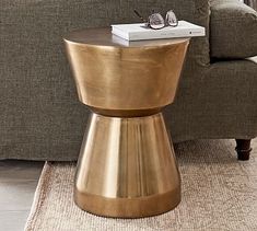 a gold end table with a book on top