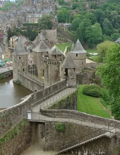 an aerial view of a castle with water in the foreground and buildings on the other side