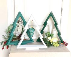 three wooden christmas trees sitting on top of a table