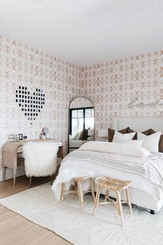 a white bed sitting in a bedroom on top of a hard wood floor next to a window