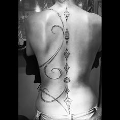 the back of a woman's body with an intricate design on her lower back