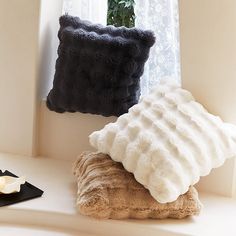 two pillows are sitting on a window sill