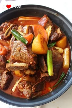 a bowl filled with meat and vegetables on top of a table