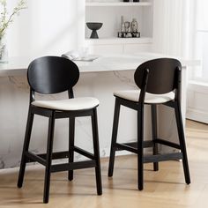 two black and white chairs sitting in front of a counter