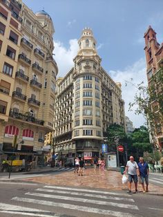 people crossing the street in front of buildings