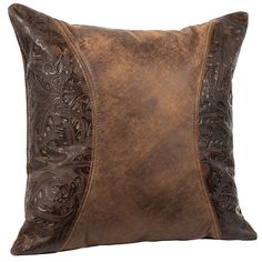 a brown leather pillow with an intricate design