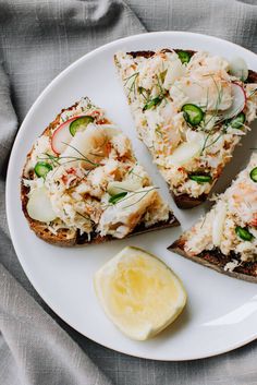 a white plate topped with slices of bread covered in veggies and toppings