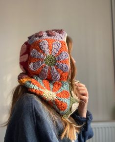 a woman is wearing a crocheted hat with flowers on the front and sides