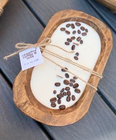 a wooden tray with coffee beans on it and a tag hanging from the handle that says,