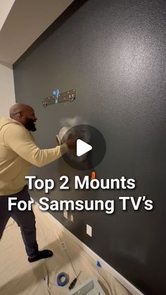 a man is painting a wall with the words top 2 mounts for samsung tvs