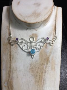 I love Victorian and Renaissance style statement necklaces with a magical and timeless flair, and I hope I've captured it within this piece! I shall fabricate for you this gorgeous Elvish/Renaissance style necklace, in sterling silver, with a center 8mm Blue Topaz and two side 4mm Amethyst gemstones. The center gemstone is 8mm round and the two sides are 4mm round. The chain will be soldered to each side and I will use a 1.2mm thick sterling box chain with a lobster claw clasp for added straight Magical Gemstone Pendant Jewelry, Magical Handmade Pendant Jewelry, Silver Gemstone Mystical Necklace, Silver Gemstone Necklace With Mystical Style, Silver Mystical Gemstone Necklace, Mystical Sterling Silver Necklace For Gift, Enchanting Silver Necklace, Magical Silver Gemstone Jewelry, Mystical Silver Gemstone Necklace