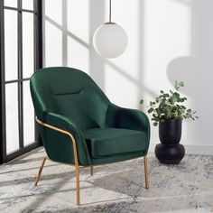 a green chair sitting on top of a rug next to a plant in a vase