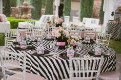 a table set up for a wedding reception with zebra print cloths and pink napkins