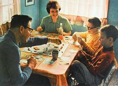 a group of people sitting around a wooden table