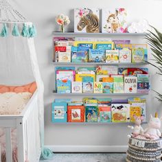 a baby's room with bookshelves and stuffed animals on the wall next to a crib