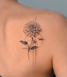 a woman's back with a flower tattoo on it