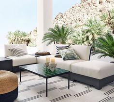 a living room filled with lots of furniture under a wooden ceiling covered in greenery