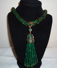 Lovely green jade, green onyx, and gold-colored beads were hand-knitted on vintage gold wire to make this necklace.  This necklace features a tassel pendant made of emerald green jade.  The set includes both the necklace and earrings.  The knitted necklace is 31 inches long, not including the pendant.  The tassel pendant measures 5 inches long and 2 1/2 inches wide.  The matching earrings are made from matching green jade and onyx, and are 2 inches long from the top of the hook.   The knitted necklace can be shortened upon request. Luxury Green Onyx Emerald Necklace, Luxury Green Lariat Necklace, Knitted Necklace, Necklace And Earrings Set, Green Onyx, Gold Wire, Green Jade, Necklace And Earrings, Jade Green