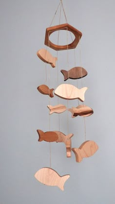 a wooden mobile with fish hanging from it's sides