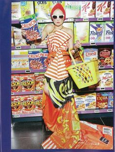 a woman with red hair and sunglasses is holding a yellow basket in front of some cereal