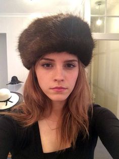 a woman with long hair wearing a fur hat