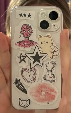 someone holding up their phone case with stickers on it