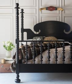 a bed with black headboard and foot board