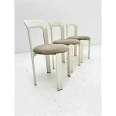 three chairs sitting next to each other on a white floor