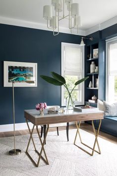 a living room with blue walls and a white rug on the floor next to a wooden table