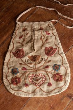 an embroidered bag sitting on top of a wooden floor