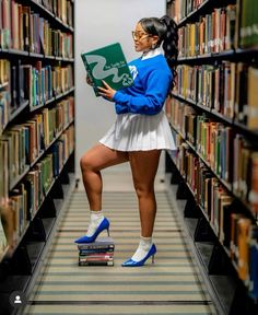 a woman standing in the middle of a library holding a book