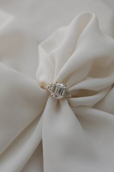 a close up view of a white fabric with a diamond ring on it