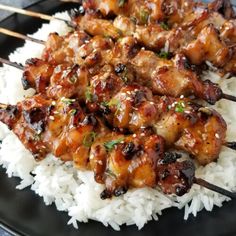 chicken and rice with chopsticks on a black plate