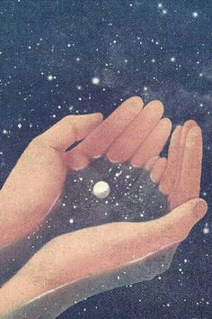 two hands are holding an object in the air with stars and snow around them on a black background