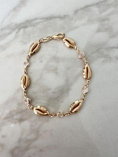 Perfect worn on its own or layered with our other bracelets. 18k gold filled.  7" length *Ready to ship *18k gold filled is a more affordable alternative to solid gold jewelry. Gold filled is a layer of gold bonded onto a base metal with heat and pressure that contains 100+ times more gold than gold plated jewelry.  *It is very durable and tarnish resistant.  *With proper care, gold filled jewelry can last several years. Avoid contact with harsh chemicals, perfumes, water, etc.  *Gold filled jewelry can be worn by people with sensitive skin because it is hypoallergenic, lead free and nickel free. Gold Seashell Bracelet, Coastal Bracelet, Sea Shell Jewelry, Seashell Bracelet, Cz Bracelet, Beach Bracelets, Golden Beach, Seashell Jewelry, Gold Bond