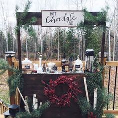 a hot chocolate bar decorated with greenery and christmas wreaths