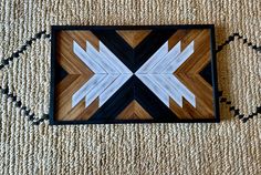 a wooden frame with white and black arrows on the bottom is sitting on a carpet