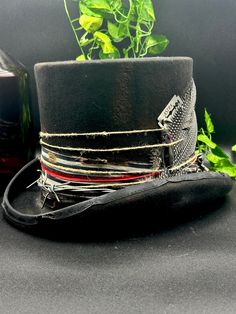 🎩 Custom Top Hat - Symbol of Freedom and Elegance! 🌟 Explore the historical evolution of this iconic accessory, from the French Revolution to the elegance of the 19th century. Our tall top hat is a unique work of art, with a black base painted in relief, decorated with vintage fabric, feathers, barbed wire, labradorite and aluminum, all handmade. Characteristics: Black base painted in relief. Handcrafted decorations with vintage fabrics, feathers and barbed wire. Labradorite and aluminum for a Wire Mandala, Mad Hat, Fabric Feathers, Hat Aesthetic, The French Revolution, Custom Top, Painted Hats, Handcrafted Decor, Hat Ideas