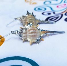 "Description: Dazzle your friends as you show off these statement large shell dangle earrings! They hang from sterling silver earwire and make a lovely boho bridesmaid gift or gift for your favorite beachcombing buddy! The holidays are right around the corner - this is the PERFECT gift for the mermaid in your life. They're also perfect for wives, daughters, teachers, coworkers, and anyone who loves the beach! Shell Type: Silver Plated Murex   Size: The shells vary from just under 2\" to just ove Unique Nickel-free Shell-shaped Earrings, Shell-shaped Earrings For Beach Season Gift, Shell Earrings For Beach Season Gift, Handmade Shell Earrings For Beach Season, Bohemian Shell Earrings Nickel Free, Nickel Free Shell Bohemian Earrings, Bohemian Nickel-free Shell Earrings, Beach Season Shell Earrings Gift, Beach Season Gift Shell Earrings