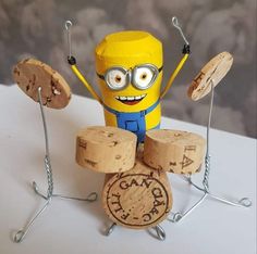 a yellow toy is sitting on top of some wine corks and has eyes that look like a minion