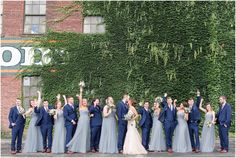 a large group of people standing next to each other in front of a green wall