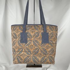 a brown and blue bag sitting on top of a wooden stand