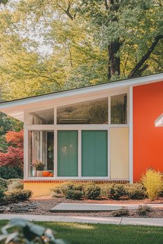 an orange and white house sitting in the middle of a lush green park with lots of trees