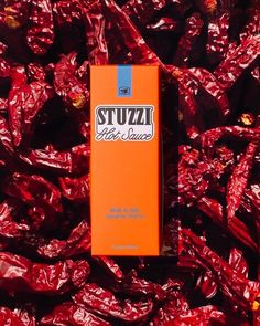 an orange box sitting on top of a pile of red chili florets with the word stuizz in it