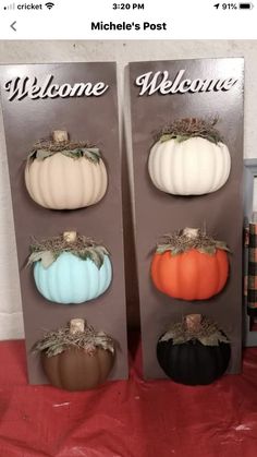 four pumpkins are sitting in front of a welcome sign